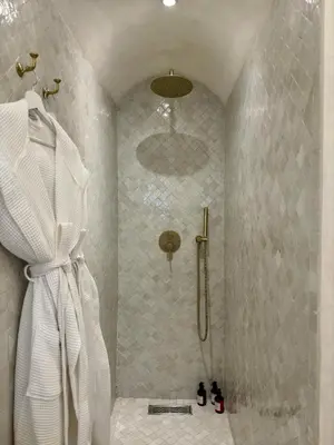 a bathroom with a shower with a shower curtain at Riad LallaBaya in Marrakech