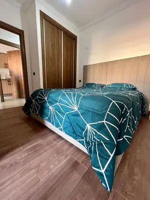 a bedroom with a bed with a blue and white comforter at appartement 2chambres salon Nour8 in Marrakech