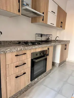 a kitchen with wooden cabinets and a stove top oven at appartement 2chambres salon Nour8 in Marrakech