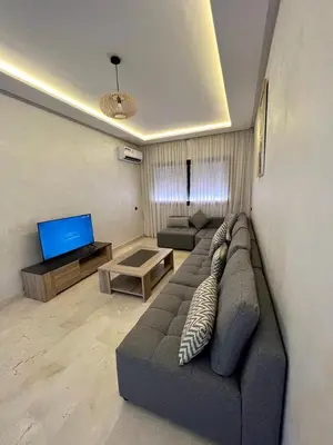 a living room with a couch and a tv at appartement 2chambres salon Nour8 in Marrakech