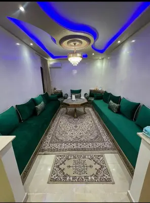 a living room with a green couch and a table at Superbe Appartement proche centre marrakech, neuf tout équipé in Marrakech
