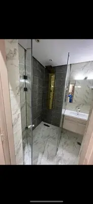 a bathroom with a shower and a sink and a mirror at Superbe Appartement proche centre marrakech, neuf tout équipé in Marrakech