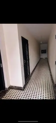 a hallway with a black door and a tiled floor at Superbe Appartement proche centre marrakech, neuf tout équipé in Marrakech