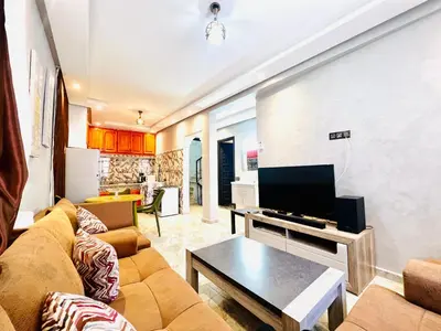 a living room with a couch and a tv at Al Hanae Family Aparts in Marrakech