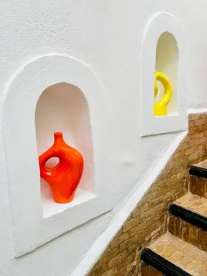 a red vase sitting on a shelf in a wall at Riad Darna 4 chambres avec piscine et petit déjeuner in Marrakech