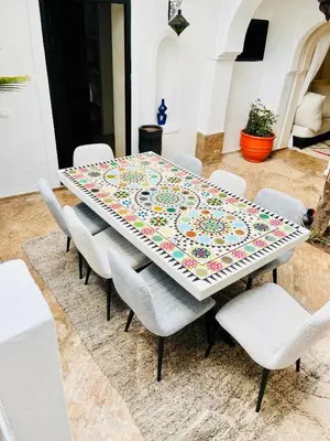 a table with chairs and a quilt on top of it at Riad Darna 4 chambres avec piscine et petit déjeuner in Marrakech