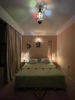 a bedroom with a bed and a stained glass window at Riad Baroud in Marrakech