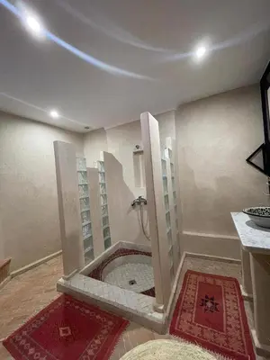 a bathroom with a shower in the corner of a room at Riad Baroud in Marrakech