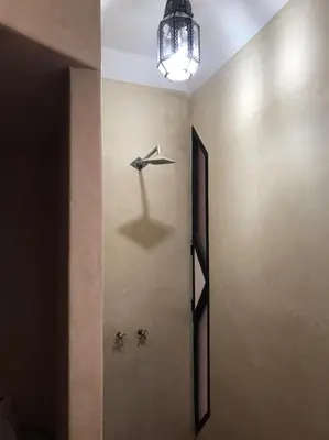 a hallway with a wall with a paper airplane on it at Riad Baroud in Marrakech