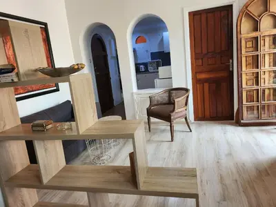 a living room with a table and a chair at Suite dans la palmeraie refaite à neuf grande Terrasse Dar Dmana in Marrakech