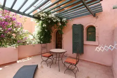 a patio with a table and chairs in a courtyard at Suite dans la palmeraie refaite à neuf grande Terrasse Dar Dmana in Marrakech