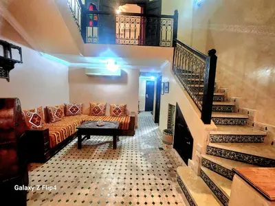 a living room with a couch and a staircase at Riad Izza in Marrakech