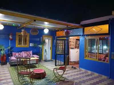 a room with a blue wall with a table and chairs at Riad dar sahrawi in Marrakech