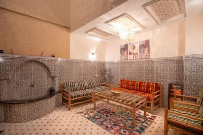 a living room with a couch and a table at Private Riad 3ch Salon, Terrasse avec Jacuzzi , à Jemaa El Fna in Marrakech