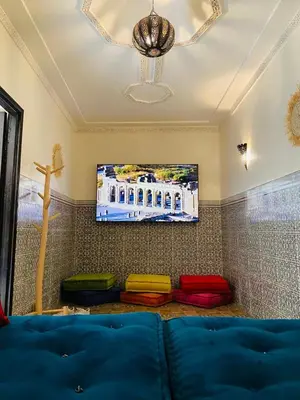 a living room with a blue couch and a tv at Private Riad 3ch Salon, Terrasse avec Jacuzzi , à Jemaa El Fna in Marrakech