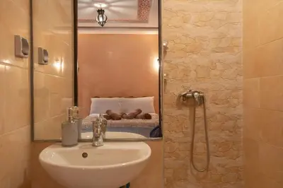 a bathroom with a sink and a mirror and a bed at Private Riad 3ch Salon, Terrasse avec Jacuzzi , à Jemaa El Fna in Marrakech