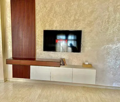 a living room with a tv on a wall at Appartement Marrakech avec piscine privée in Marrakech