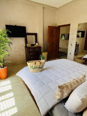a bedroom with a large white bed with a pillow at Appartement Marrakech avec piscine privée in Marrakech