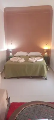 a bedroom with two beds with green sheets and pillows at Riad Dar Lilas in Marrakech