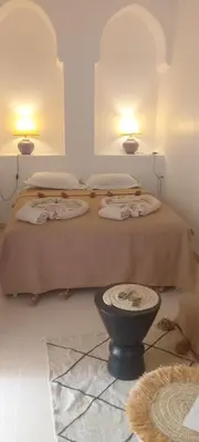 a bedroom with two beds and two lights on the wall at Riad Dar Lilas in Marrakech