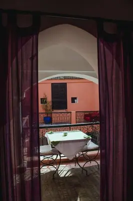 a table and chairs in a room with a window at Riad Dar Lilas in Marrakech