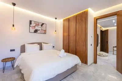 a bedroom with a white bed and a wooden door at Contemporary luxe, heart of Gueliz fibre optq IPTV in Marrakech