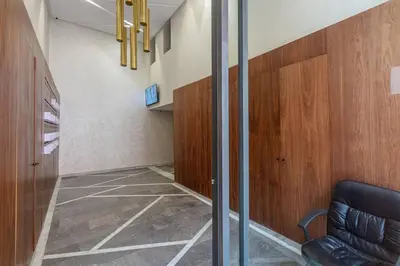 a hallway with a chair and a glass door at Contemporary luxe, heart of Gueliz fibre optq IPTV in Marrakech