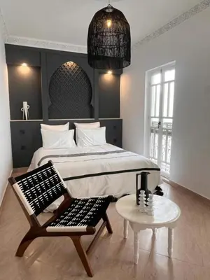 a bedroom with a bed and a chair and a table at Riad M17 & Spa - Médina in Marrakech
