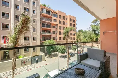 a balcony with a chair and a view of a city at Peaceful Living: Chic Apartment, Prime Location in Marrakech
