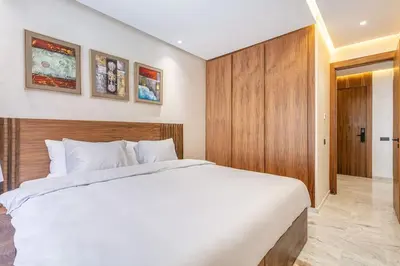 a bedroom with a white bed and a wooden wall at Peaceful Living: Chic Apartment, Prime Location in Marrakech