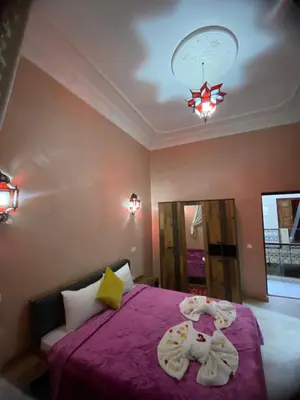 a bedroom with a purple bed and a chandelier at Riad La Bigarade in Marrakech