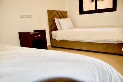 a hotel room with two beds and a night stand at Magnifique Appartement Marrakech - 2 Chambre 2 Salle de Bains in Marrakech