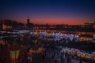 a crowd of people walking around a market at night at Magnifique Appartement Marrakech - 2 Chambre 2 Salle de Bains in Marrakech