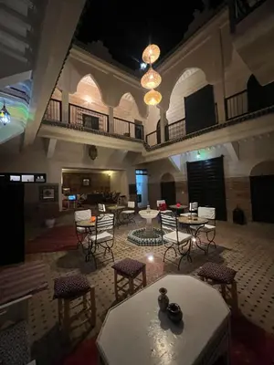 a large room with tables and chairs in a building at Riad el Adraoui in Marrakech