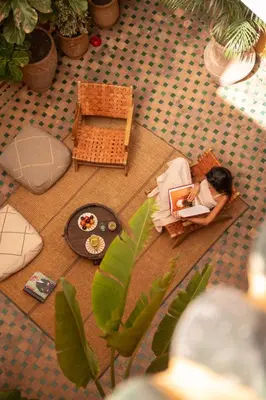 a girl sitting in a chair on the floor with a laptop at Riad Le Petit Bacha in Marrakech