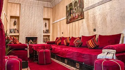 a living room with a red couch with pillows at Riad Safir Marrakech in Marrakech