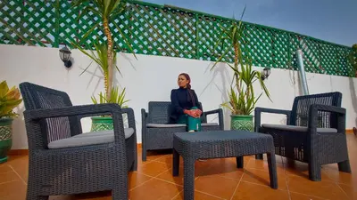 a woman sitting in a chair inbetween two chairs at Riad Safir Marrakech in Marrakech