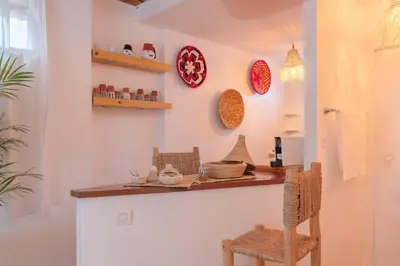 a kitchen with a counter with chairs and plates on the wall at Rooftop centre ville Marrakech in Marrakech