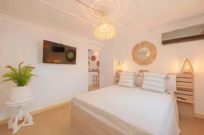 a white bedroom with a white bed and a chandelier at Rooftop centre ville Marrakech in Marrakech