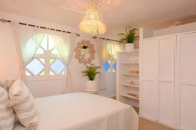 a bedroom with a white bed and a chandelier at Rooftop centre ville Marrakech in Marrakech