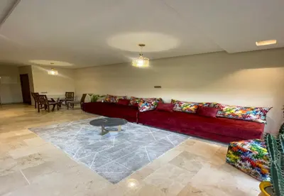 a living room with a red couch and a table at Appartement Prestigia Golf City Marrakech - Porte Agate - Gated community Rez-de-Jardin in Marrakech