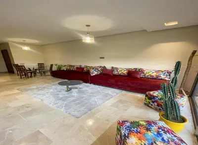 a living room with a red couch and a table at Appartement Prestigia Golf City Marrakech - Porte Agate - Gated community Rez-de-Jardin in Marrakech
