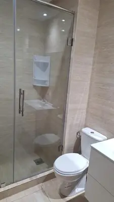 a bathroom with a toilet and a glass shower at Appartement Prestigia Golf City Marrakech - Porte Agate - Gated community Rez-de-Jardin in Marrakech