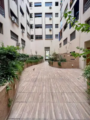 a courtyard of a building with a wooden walkway at Apparemment deux chambres salon 16 in Marrakech