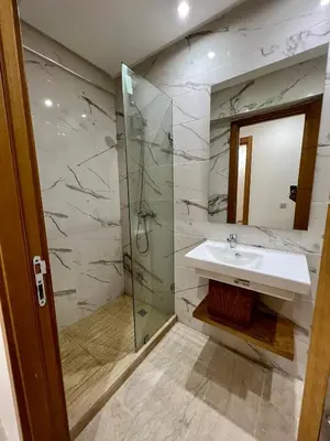 a bathroom with a sink and a glass shower at Apparemment deux chambres salon 16 in Marrakech