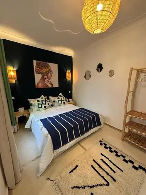 a bedroom with a bed with a blue and white blanket at Riad Dar Fena By K&G &jacuzzi in Marrakech