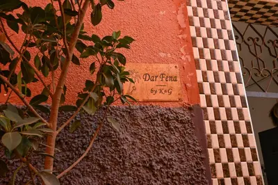 a sign on the side of a building with a tree at Riad Dar Fena By K&G &jacuzzi in Marrakech
