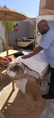 a man making a bed with a bird on it at Riad Dar Fena By K&G &jacuzzi in Marrakech