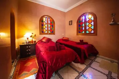 a bedroom with two beds and a stained glass window at La lune de Marrakech Riad in Marrakech