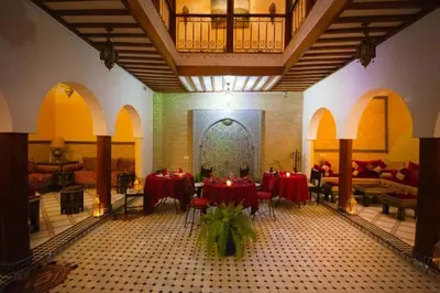 a room with tables and chairs in a building at La lune de Marrakech Riad in Marrakech